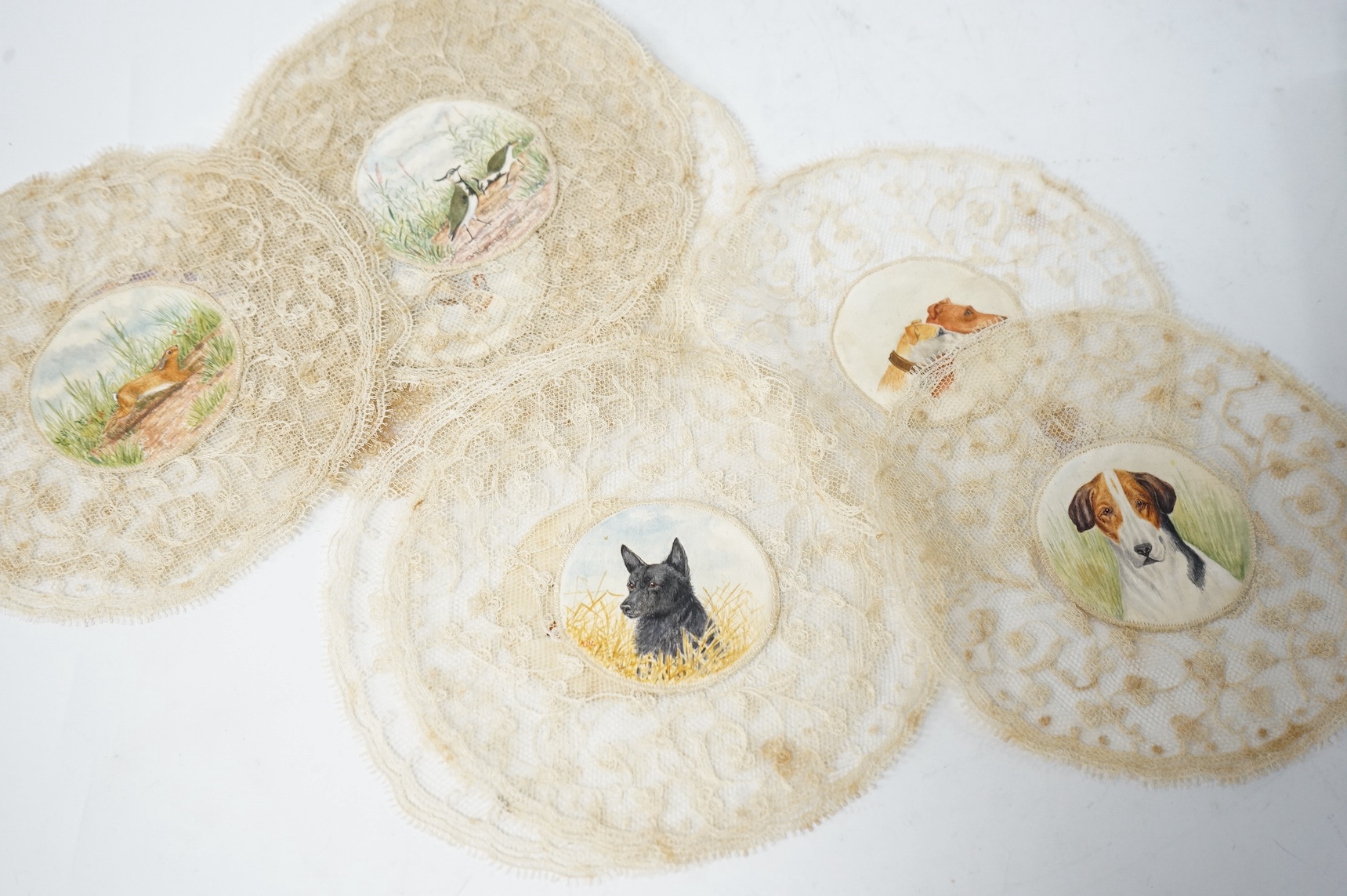 Eleven early 20th century circular mats, hand painted hunting related centres, edged with lace. 15cm diameter. Condition - some staining to lace